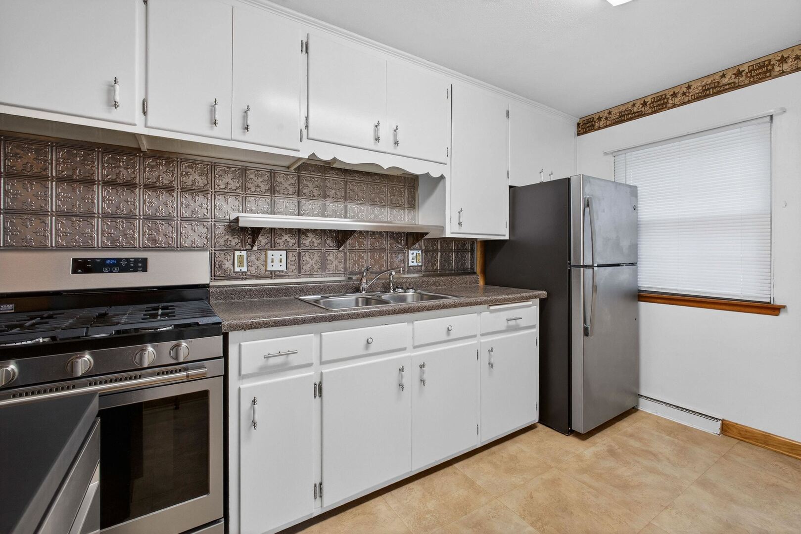 502-504 48th Street Moline, IL 61265 - Photo 10 of 31 a kitchen with stainless steel appliances granite countertop a stove a refrigerator and a white cabinets