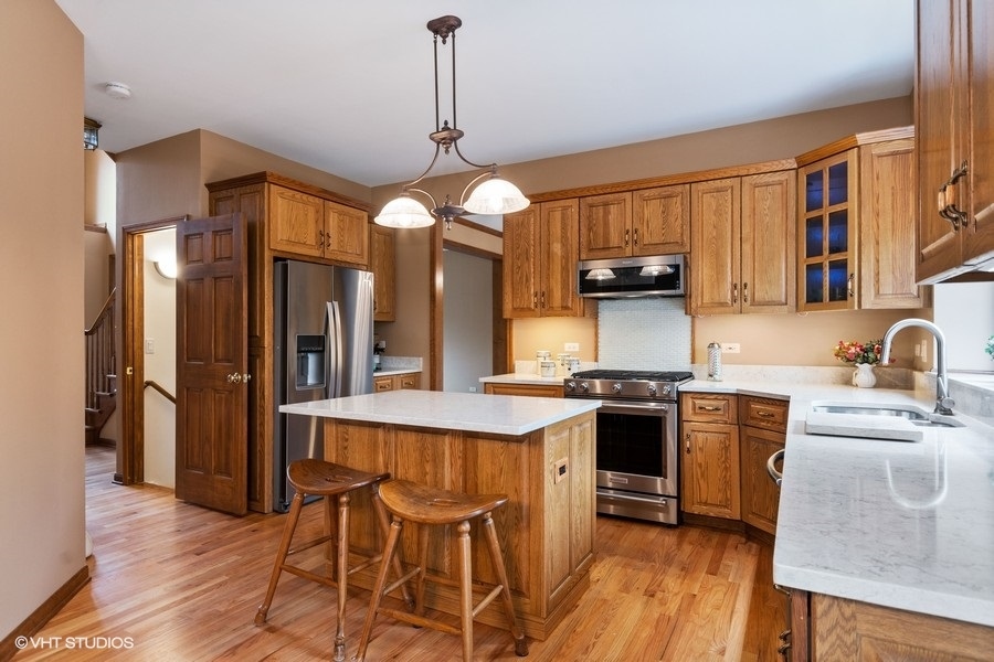 517 Ekman Drive Batavia, IL 60510 - Photo 5 of 22 a kitchen with stainless steel appliances granite countertop a stove top oven a refrigerator a sink and dishwasher
