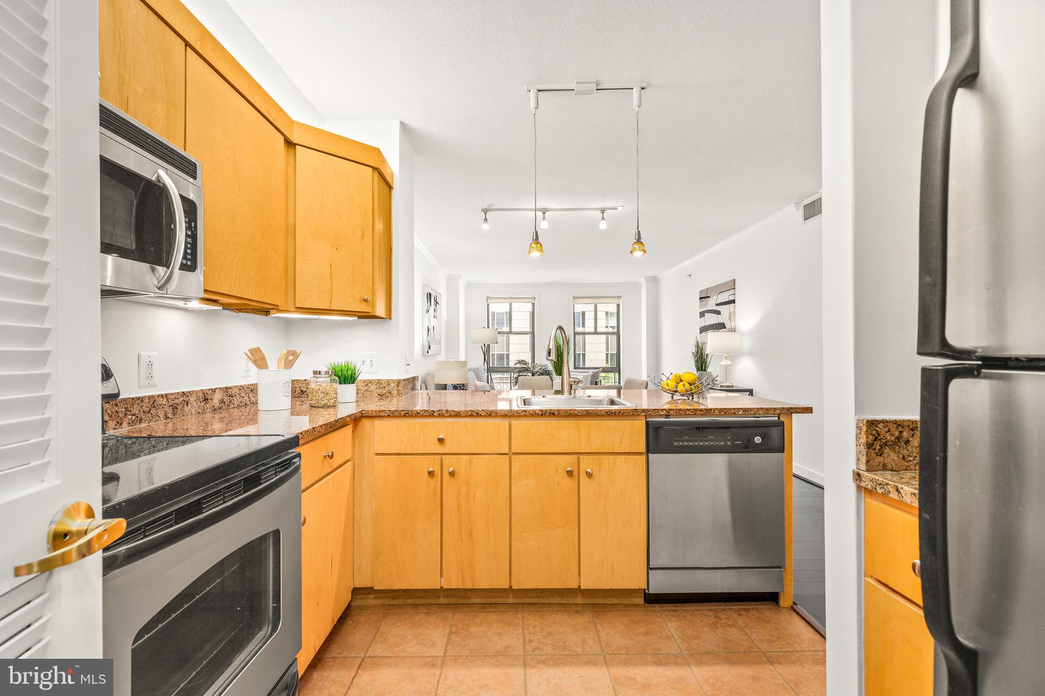 616 E Street Northwest, Unit 322 Washington, DC 20004 - Photo 12 of 33 a kitchen with stainless steel appliances granite countertop a refrigerator a stove and a sink