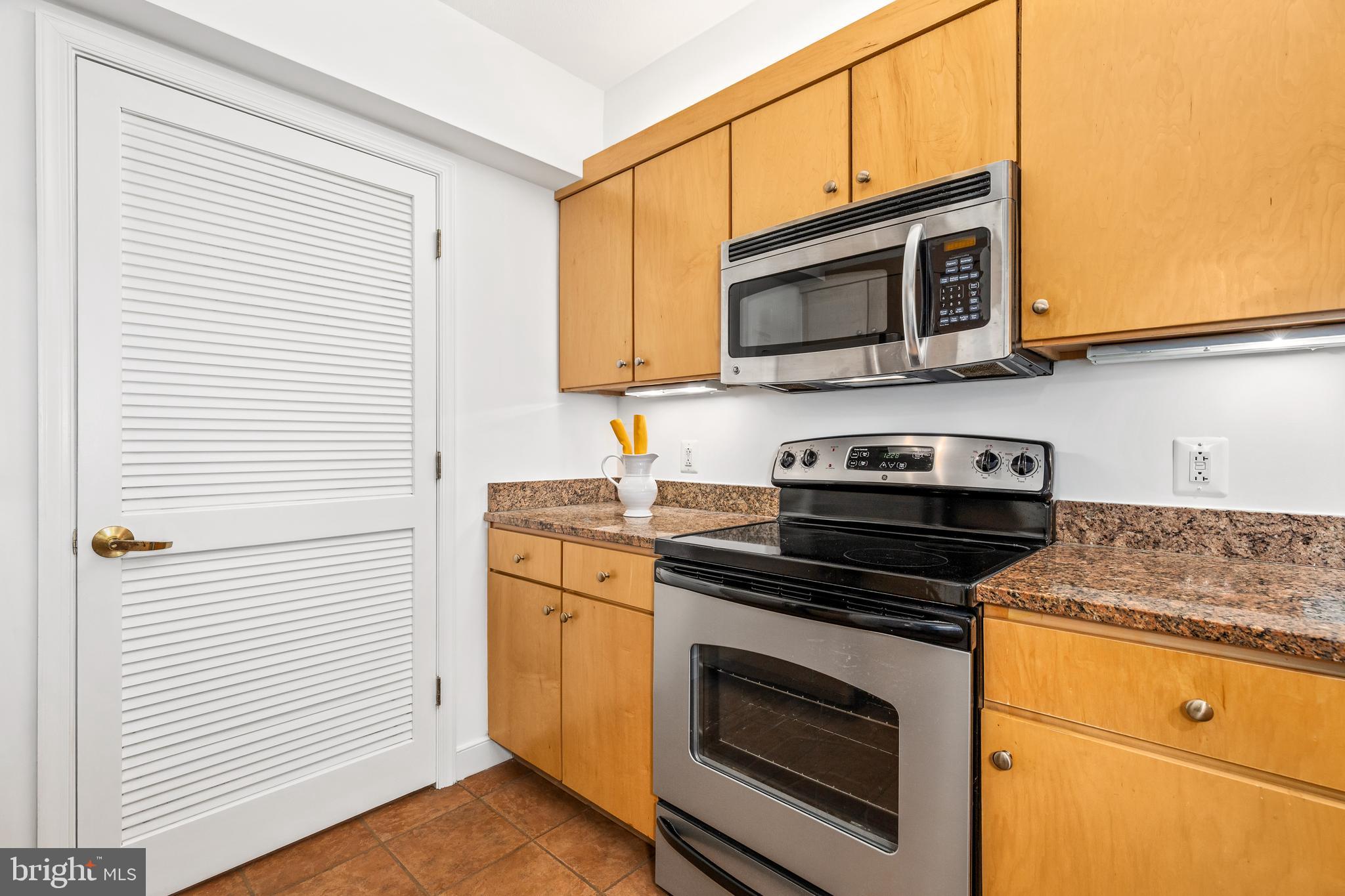 616 E Street Northwest, Unit 322 Washington, DC 20004 - Photo 10 of 33 a kitchen with stainless steel appliances granite countertop a stove microwave and sink