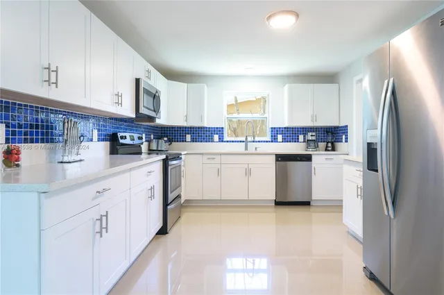 a kitchen with white cabinets and white appliances