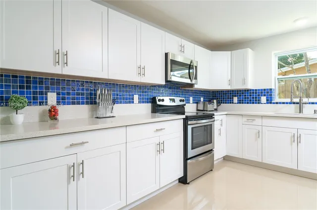 a kitchen with white cabinets stainless steel appliances and sink