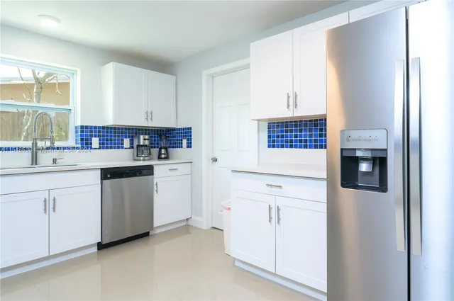 a kitchen with white cabinets and white appliances