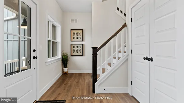 a view of a hallway with wooden floor and staircase