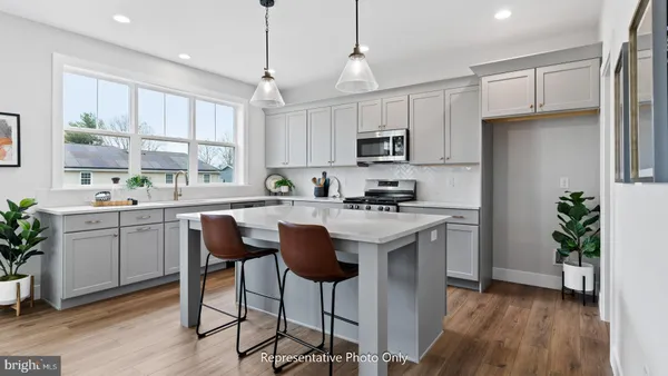 a kitchen with kitchen island granite countertop a sink a counter space appliances and cabinets