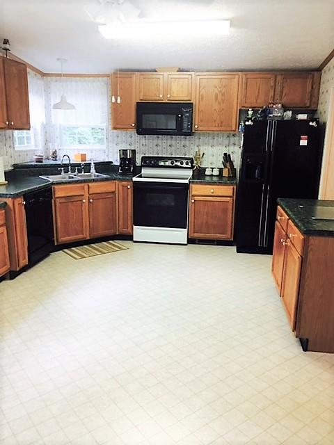 48 L Mitchell Road Kelso, TN 37348 - Photo 17 of 27 a kitchen with stainless steel appliances a sink a stove a microwave a sink a counter top space and cabinets