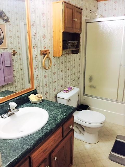 48 L Mitchell Road Kelso, TN 37348 - Photo 25 of 27 a bathroom with a granite countertop toilet sink and mirror