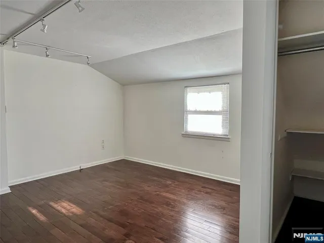 a view of a room that has wooden floor and windows in a room