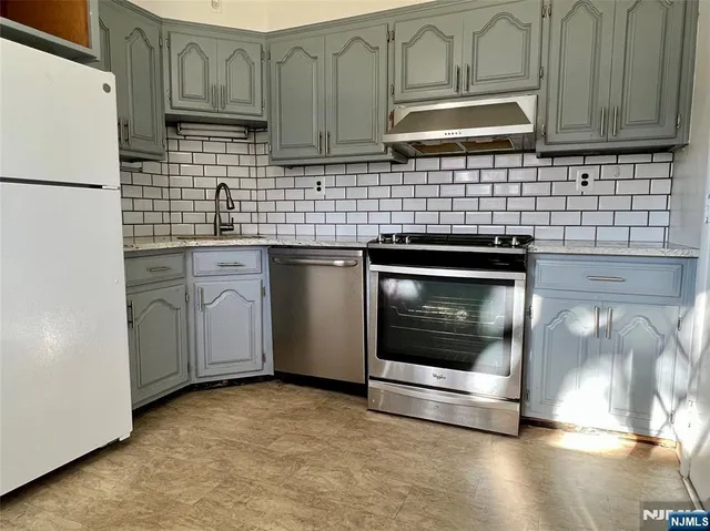 a kitchen with granite countertop cabinets stainless steel appliances and a sink
