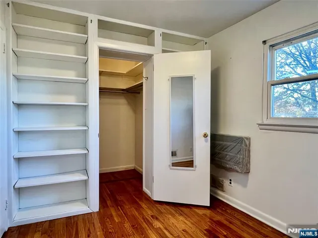 a view of walk in closet with empty racks
