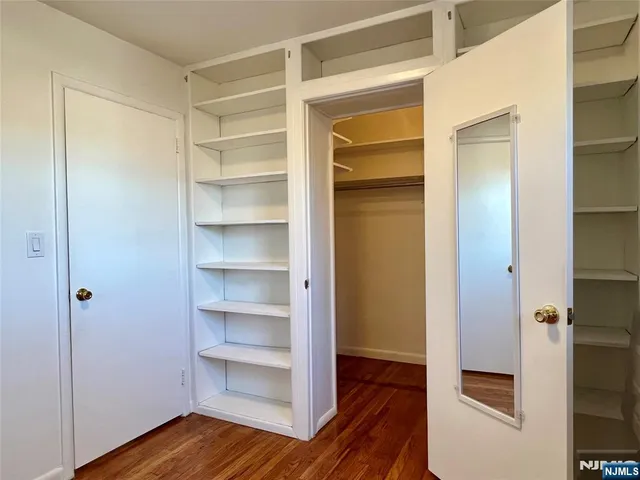 a view of walk in closet with wooden floor
