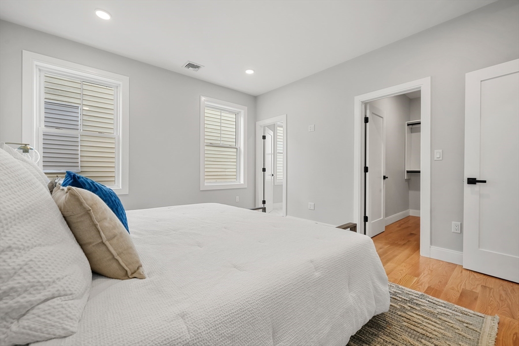 60 Fuller Street, Unit PH5 Boston, MA 02124 - Photo 14 of 32 a spacious bedroom with a bed and a wooden floor