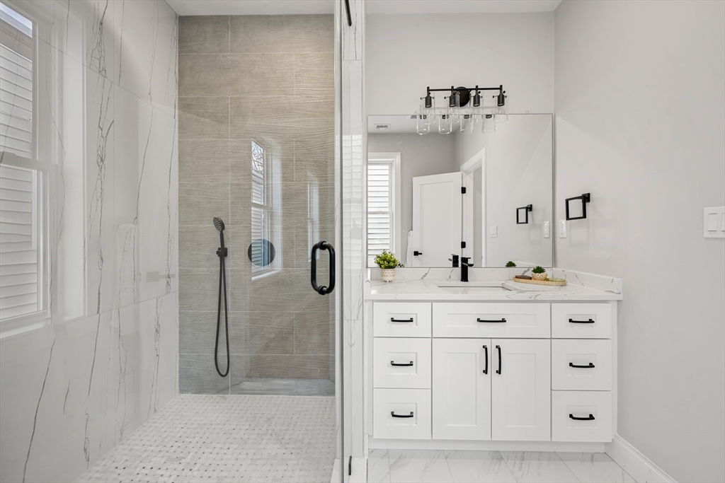 60 Fuller Street, Unit PH5 Boston, MA 02124 - Photo 17 of 32 a bathroom with a shower sink and mirror