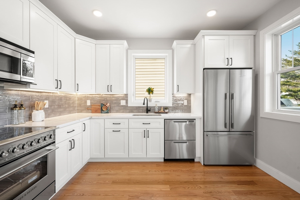 60 Fuller Street, Unit PH5 Boston, MA 02124 - Photo 7 of 32 a kitchen with white cabinets white stainless steel appliances and wooden floors