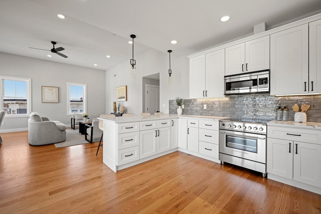 60 Fuller Street, Unit PH5 Boston, MA 02124 - Photo 8 of 32 a kitchen with stainless steel appliances white cabinets and wooden floors