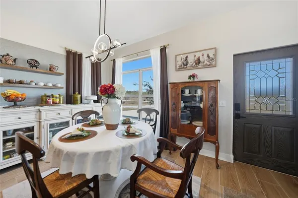 a view of a dining room with furniture a kitchen and chandelier