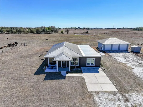 an aerial view of a house with a yard and lake view