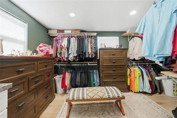 a view of walk in closet with clothes and shoes