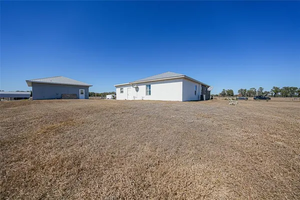 an aerial view of a house with a yard and lake view