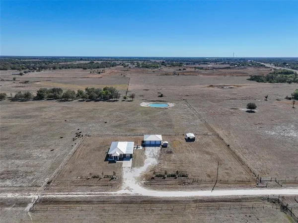 a view of a house with a swimming pool and a yard