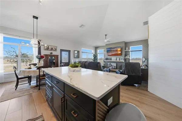 a large kitchen with a table chairs and a wooden floor