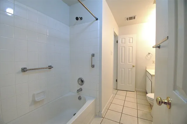 a bathroom with a bathtub shower and toilet