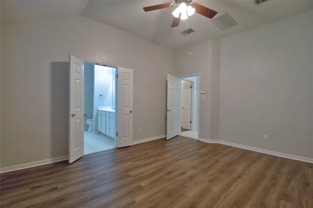 an empty room with wooden floor and chandelier