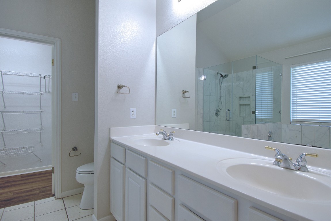 120 Greenside Lane Georgetown, TX 78633 - Photo 23 of 27 a bathroom with a granite countertop sink a toilet and a large mirror