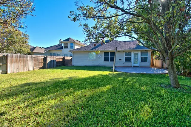 a view of a house with a yard potted plants and large tree