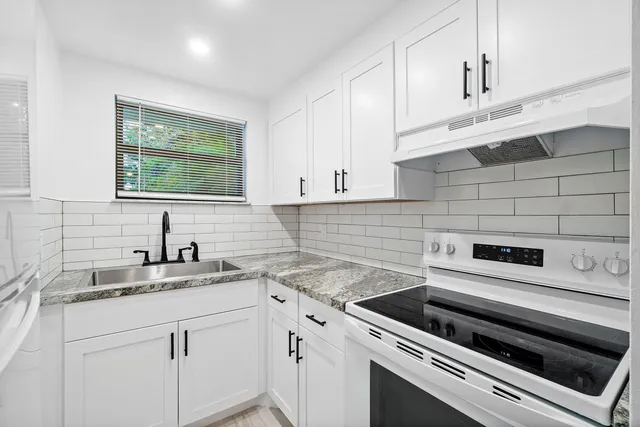 a kitchen with a sink stove and cabinets