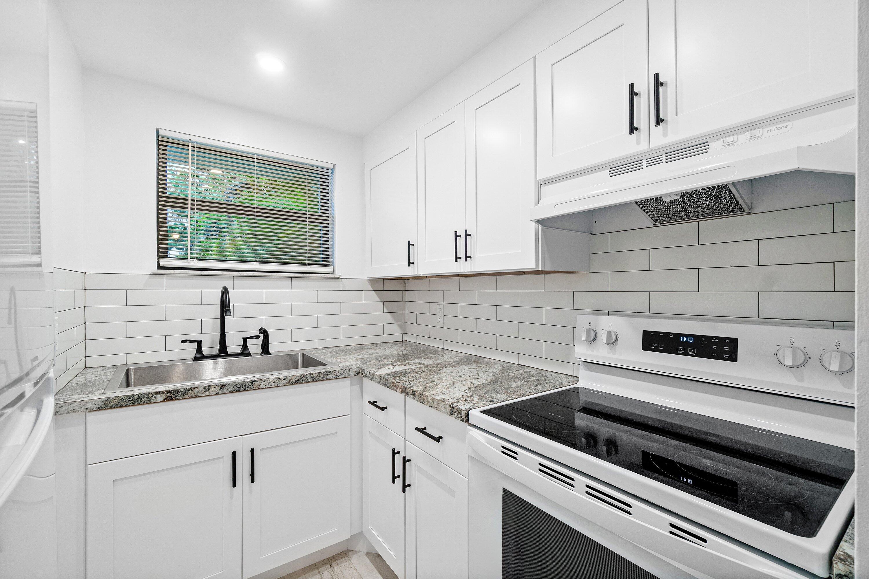 a kitchen with a sink stove and cabinets