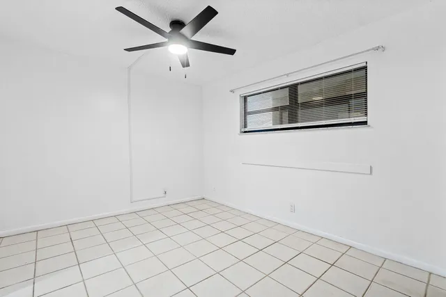 a view of empty room with cabinet and ceiling fan