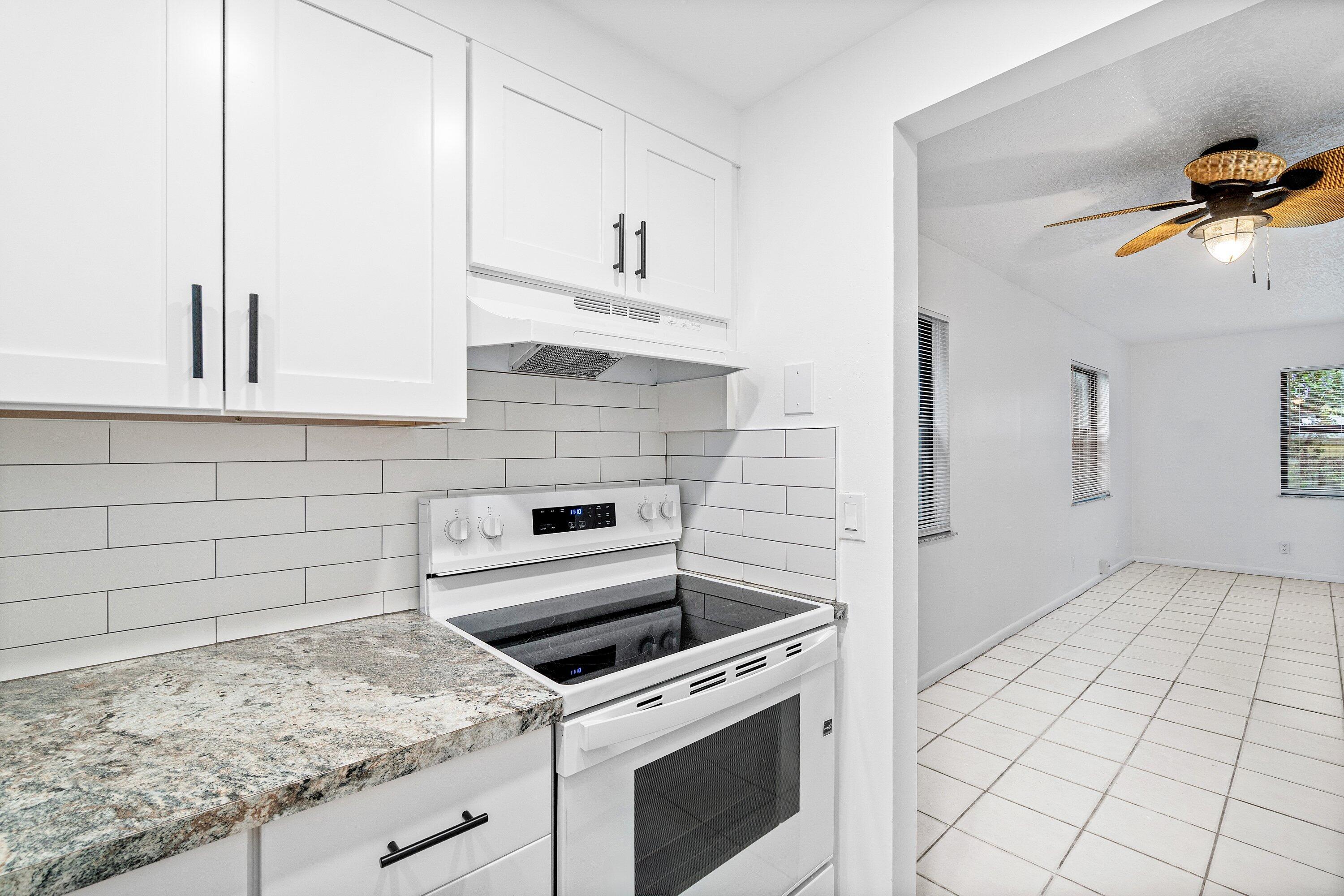 626 North Federal Highway, Unit 3 Lake Worth Beach, FL 33460 - Photo 7 of 23 a kitchen with granite countertop white cabinets and white appliances