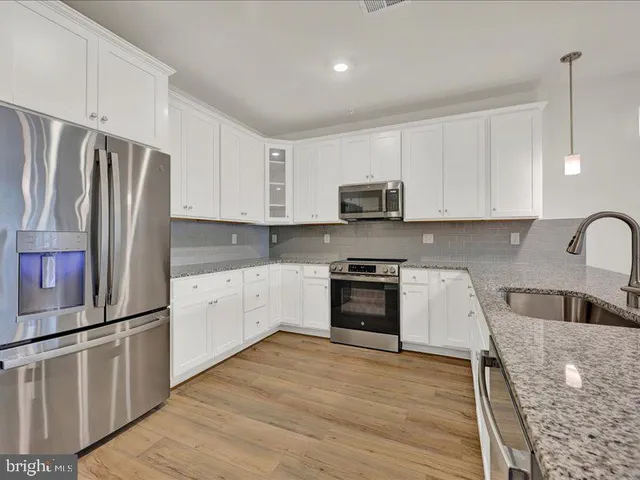 a kitchen with stainless steel appliances granite countertop a refrigerator sink and stove
