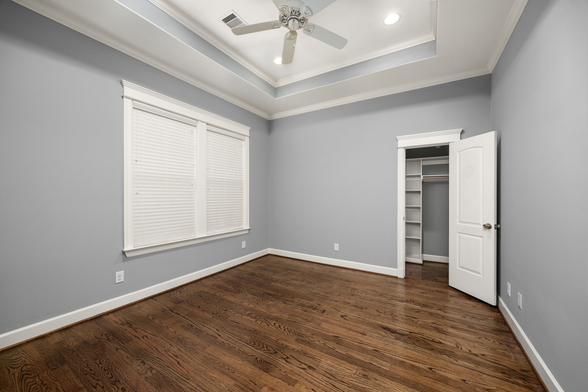 619 Rutland Street, Unit B Houston, TX 77007 - Photo 23 of 33 an empty room with wooden floor chandelier fan and windows