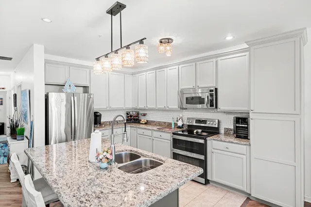 a kitchen with granite countertop a sink stainless steel appliances and cabinets