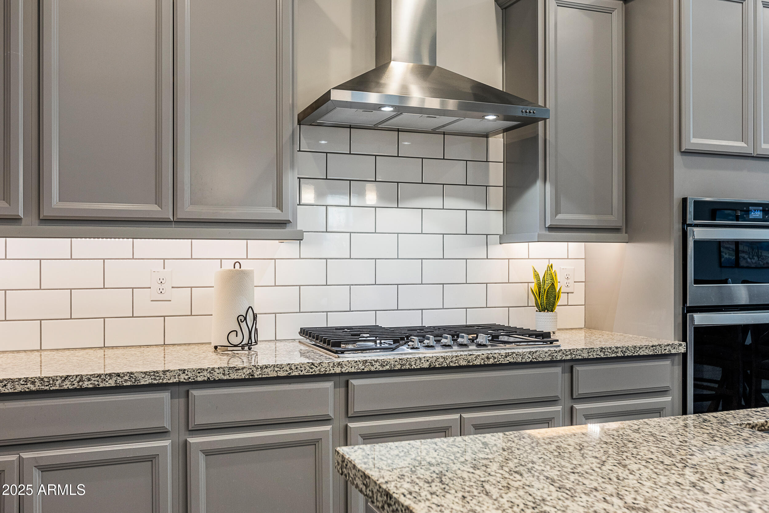 23030 East Estrella Road Queen Creek, AZ 85142 - Photo 16 of 47 a kitchen with granite countertop a stove a cabinets and wooden floor