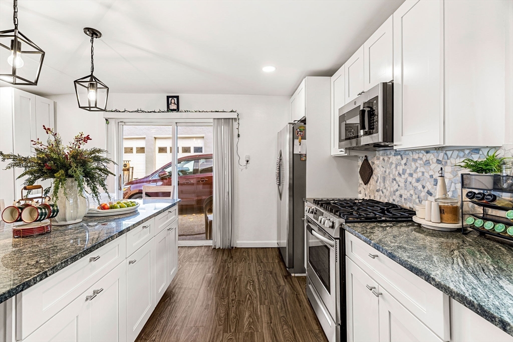 a kitchen with stainless steel appliances granite countertop a sink stove and refrigerator