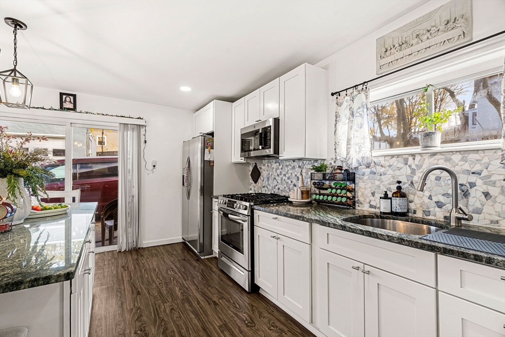 24 Hooper Street Chelsea, MA 02150 - Photo 6 of 15 a kitchen with stainless steel appliances granite countertop a stove a sink dishwasher and a refrigerator with wooden floor