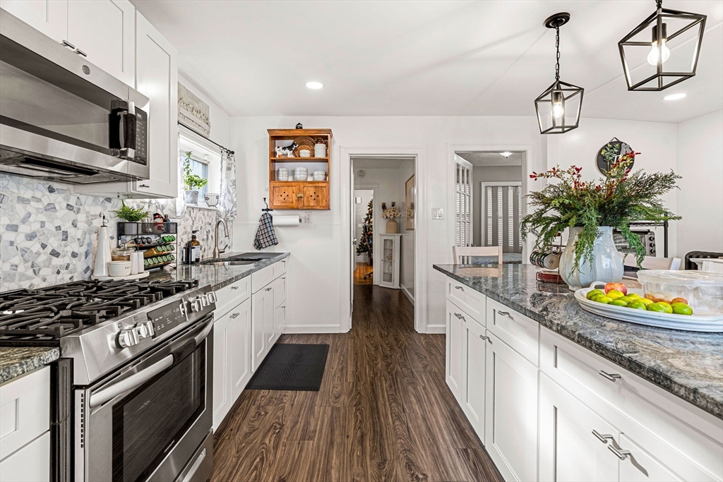 24 Hooper Street Chelsea, MA 02150 - Photo 7 of 15 a kitchen with stainless steel appliances granite countertop a sink a stove and cabinets
