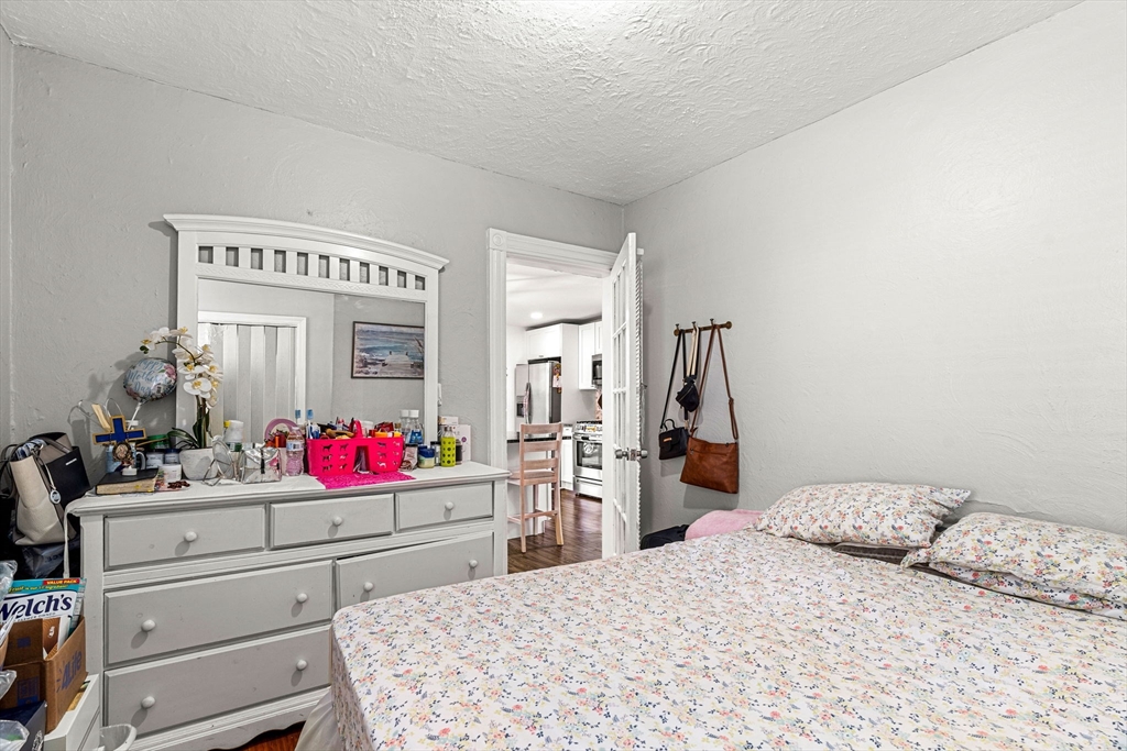 24 Hooper Street Chelsea, MA 02150 - Photo 10 of 15 a bedroom with a bed and cabinets