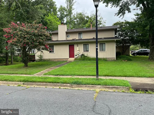 a white house that has a tree in front of it