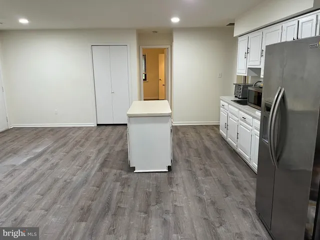 a kitchen with granite countertop white cabinets and stainless steel appliances