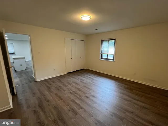 an empty room with wooden floor and mirror