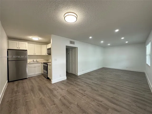 a kitchen with stainless steel appliances a refrigerator and a stove top oven
