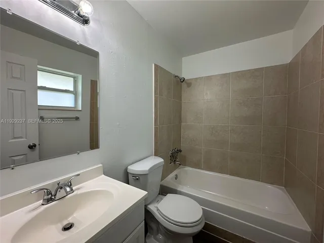 a bathroom with a bathtub shower sink mirror vanity and toilet