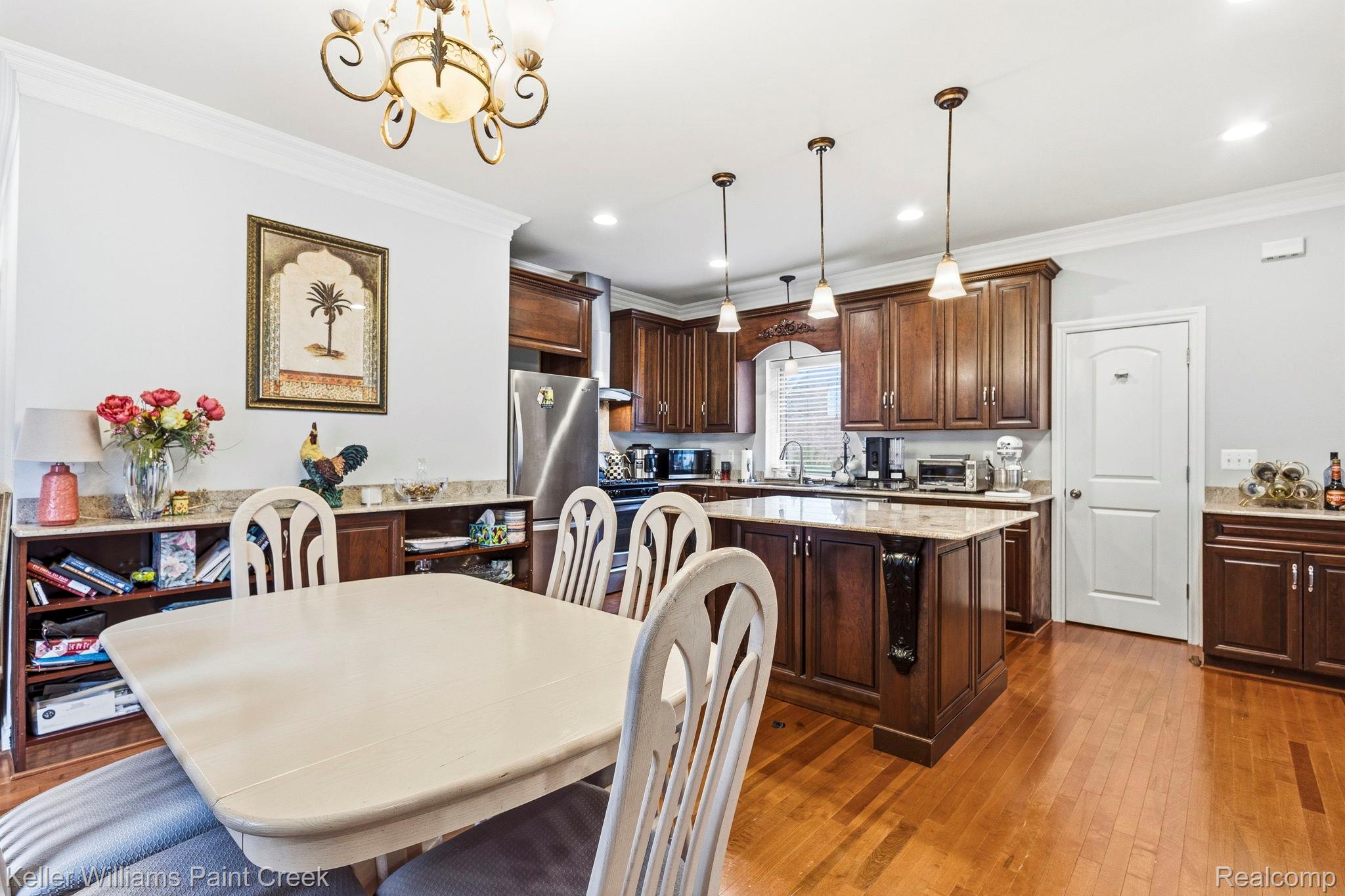 418 Oak Street Rochester, MI 48307 - Photo 17 of 38 Dining area featuring a chandelier, ornamental molding, and dark wood-type flooring