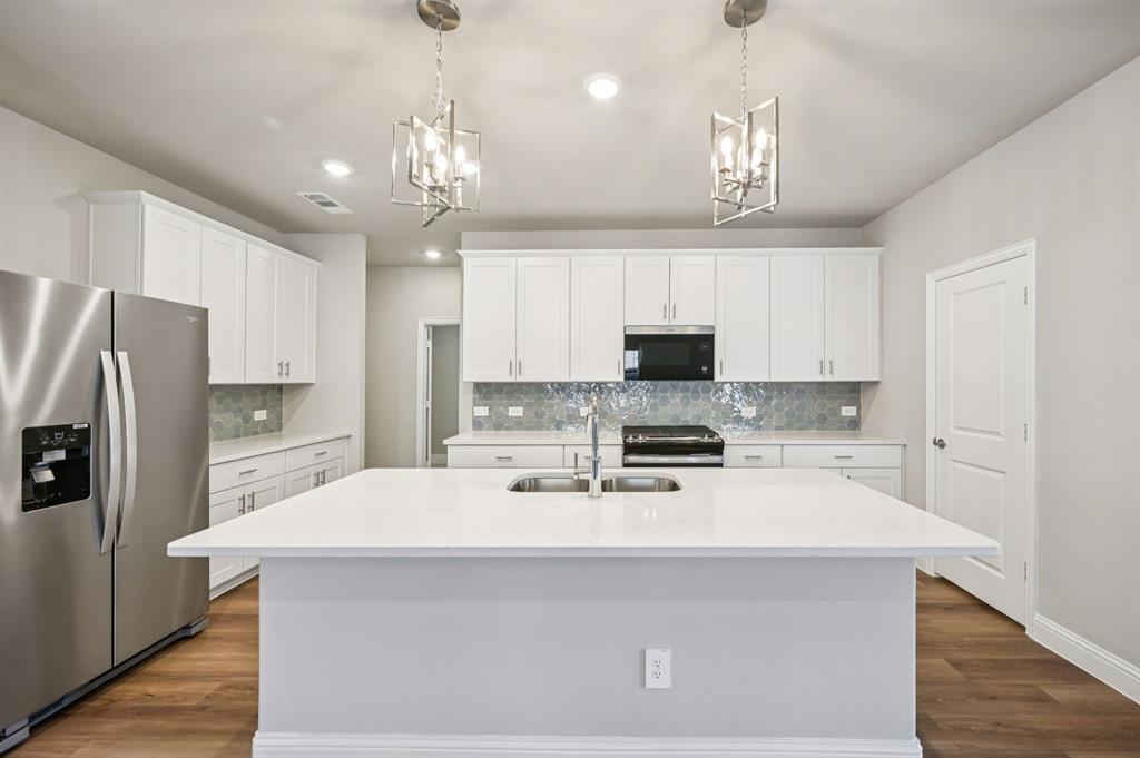 505 Stagg Street McKinney, TX 75069 - Photo 11 of 39 a kitchen with kitchen island a sink stainless steel appliances and cabinets