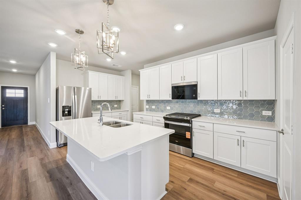 505 Stagg Street McKinney, TX 75069 - Photo 12 of 39 a kitchen that has a lot of white cabinets and stainless steel appliances