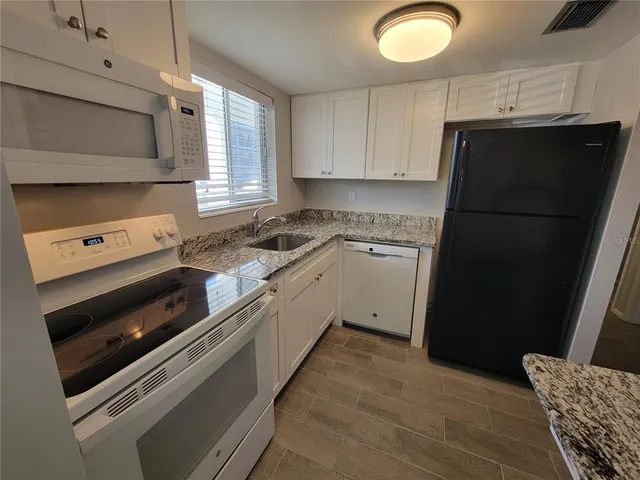 a kitchen with a sink stove and cabinets